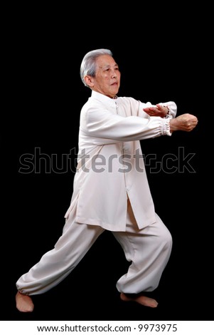 Chinese Elderly performing Tai Chi Isolated on Black Background