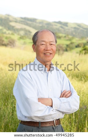 Happy Smiling Chinese Elderly Standing in front of Farmland