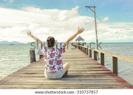 women sit on Wooden pier, Summer, Travel, Vacation and Holiday concept - Wooden pier in Kho mak, Thailand