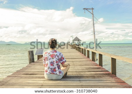 women sit on Wooden pier, Summer, Travel, Vacation and Holiday concept - Wooden pier in Kho mak, Thailand