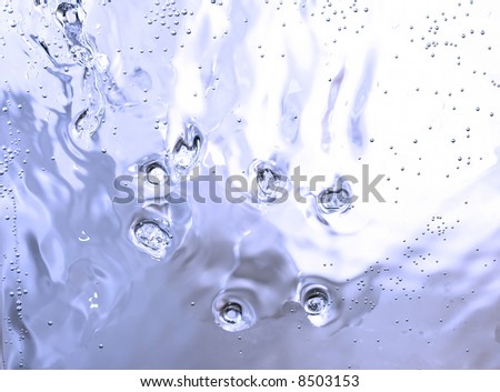 still-life abstract texture background composition: blue ice surface with water droplets, rivulets, streams and frozen still bubbles of air