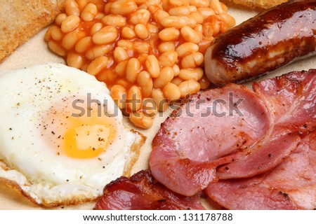 Full English cooked breakfast with bacon, sausage, fried egg and baked beans.