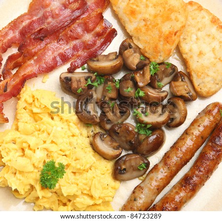 Cooked breakfast with scrambled eggs, bacon, sausages, sauteed mushrooms and hash browns.
