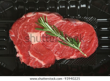 Rib-eye beef steak in plastic packing tray