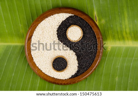 The white and black sesame seeds is yin yang on a banana leaf (Sesamum orientale L.).
