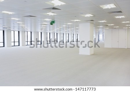 An empty open plan office area, with plenty of windows
