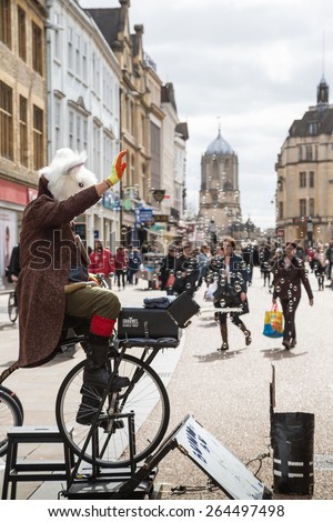 OXFORD, UK - MARCH 27, 2015: A street artist blows bubbles which are enjoyed by people passing by on Cornmarket Street, Oxford