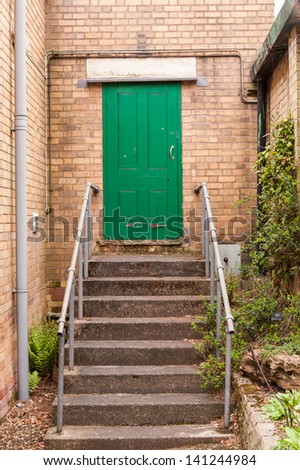 green door at the top of steps with handrails.
