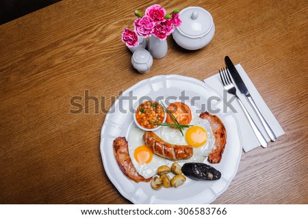 Full English breakfast with egg, bacon, beans, sausage, mushrooms and tomato.