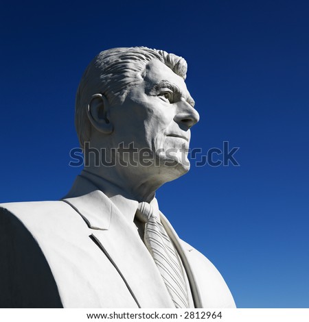 Bust of Ronald Reagan sculpture against blue sky in President\'s Park, Black Hills, South Dakota.