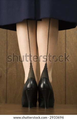 Close-up shot of Caucasian female in skirt with black heels.