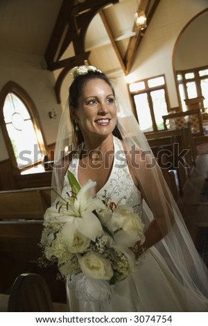 Portrait of mid-adult bride holding bouquet leaving a church.
