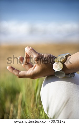 Close-up of young adult Asian female's hands in meditating position.