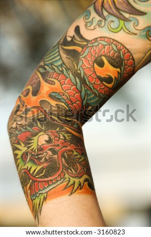 Close up of dragon tattoo on arm of Caucasian woman.