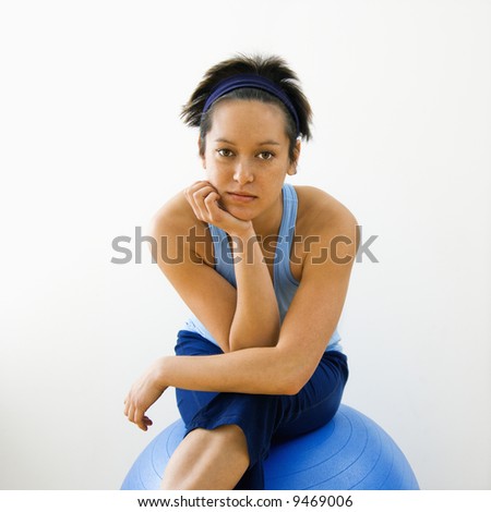 Portrait of young woman sitting on fitness balance ball.