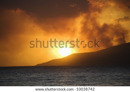 Maui, Hawaii sunset with ocean and island mountain on Maui, Hawaii.