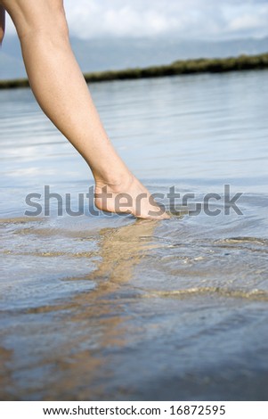 Woman dipping her toe in the water to test temperature.
