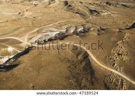 Aerial view of a of rural, desert landscape with a road running through it. Horizontal shot.