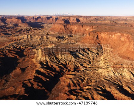 Aerial view of canyons carved out of the rocky desert landscape. Horizontal shot.