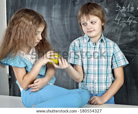 boy gives green apple sad girl at school