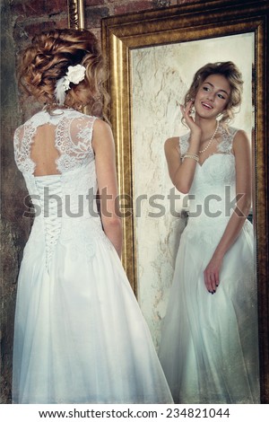 beautiful bride looks in the mirror