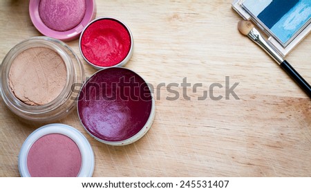 colorful makeup items scattered across a wooden surface
