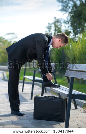Young businessman with tie his shoelace