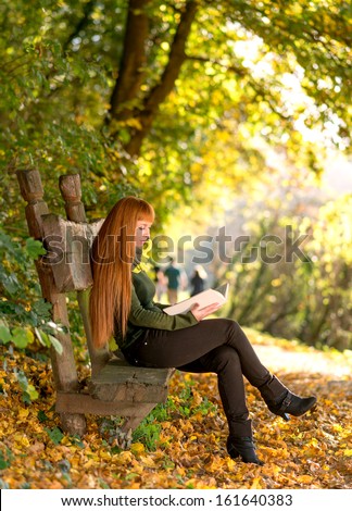 Woman reading in the autumn nature