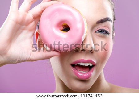 Beautiful woman with donuts, one eye than have a pink donut