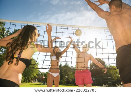 Friends play volleyball on the beach