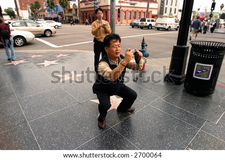Asian tourist taking a picture with point and shoot camera at the Hollywood Blvd., L.A., California