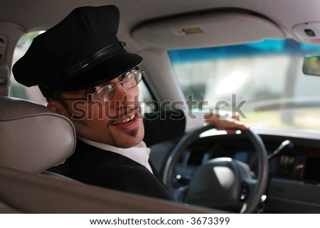 Portrait of a handsome male chauffeur sitting in a car talking to passenger.