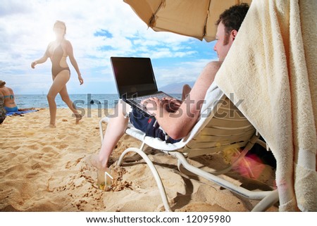 Man working on laptop at tropical beach in Hawaii