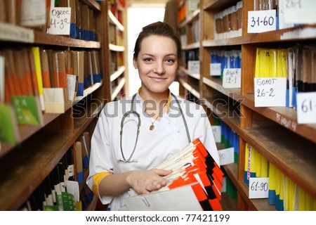 Portrait of female doctor in white lab coat with medical records.