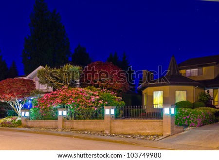 Night image of the house with front yard nice colorful garden