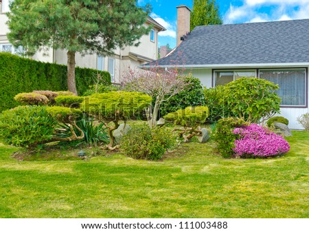 Nicely trimmed and landscaped front yard. Landscape design.