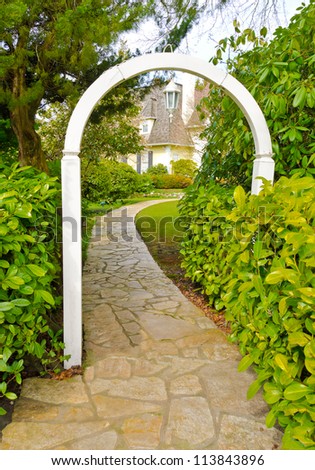 Nicely paved curved doorway. Leads to the house thorough the wooden arch. House entrance. Landscape design.