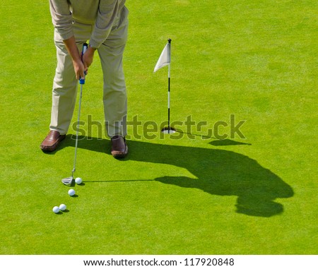 Male golfer about to hit. Training course.