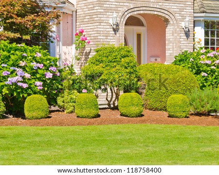 Landscape design. Nicely trimmed bushes in front of the house,  front yard