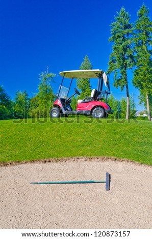 Golf cart at the golf course in front of the sand bunker