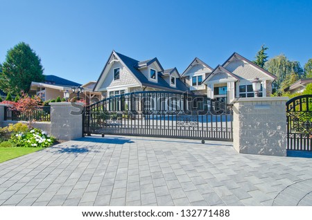 Big custom made luxury house behind the gates and nicely paved driveway in the suburbs of Vancouver, Canada.