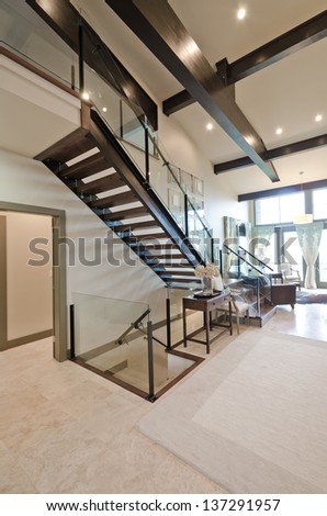 Outlook at the luxury spacious  modern room with the  fireplace and stairs to the upper level. Interior design. Vertical.