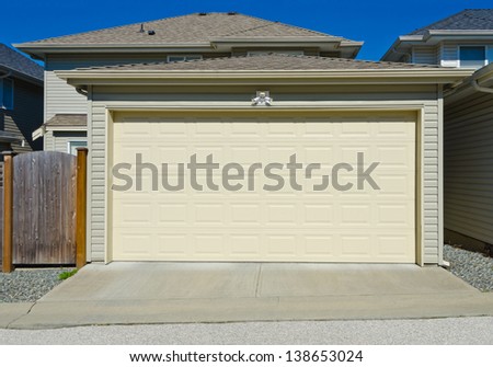 Double doors garage with nicely paved long driveway. North America.