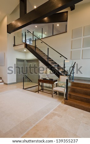 Outlook at the luxury spacious modern room with the stairs to the upper level. Interior design. Vertical.