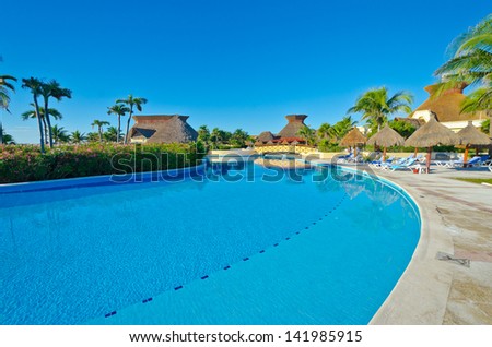 Swimming pool with deep blue sky and dark blue water at the luxury mexican resort. Bahia Principe, Riviera Maya.
