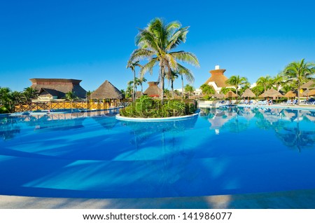 Swimming pool with deep blue sky and dark blue water at the luxury mexican resort. Bahia Principe, Riviera Maya.