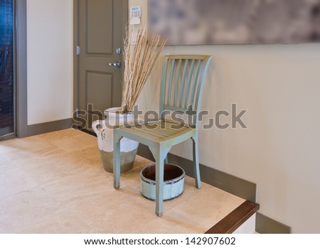 A chair and the vase in the room, hall, lobby.  Decorative fragment. Interior design.