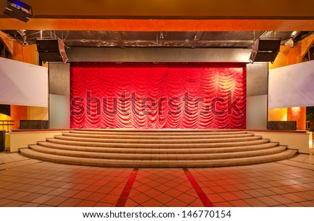 Theater stage with red curtains and steps. Theatrical scene,  the interior of the old theater of the luxury caribbean resort. Bahia Principe, Riviera Maya, Mexican Resort.