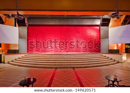 Theater stage with red curtains and steps. Theatrical scene,  the interior of the old theater of the luxury caribbean, tropical resort. Bahia Principe, Riviera Maya, Mexican Resort.