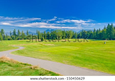 Trail at the beautiful golf course with a mountains and dark blue sky. Vancouver, Canada.